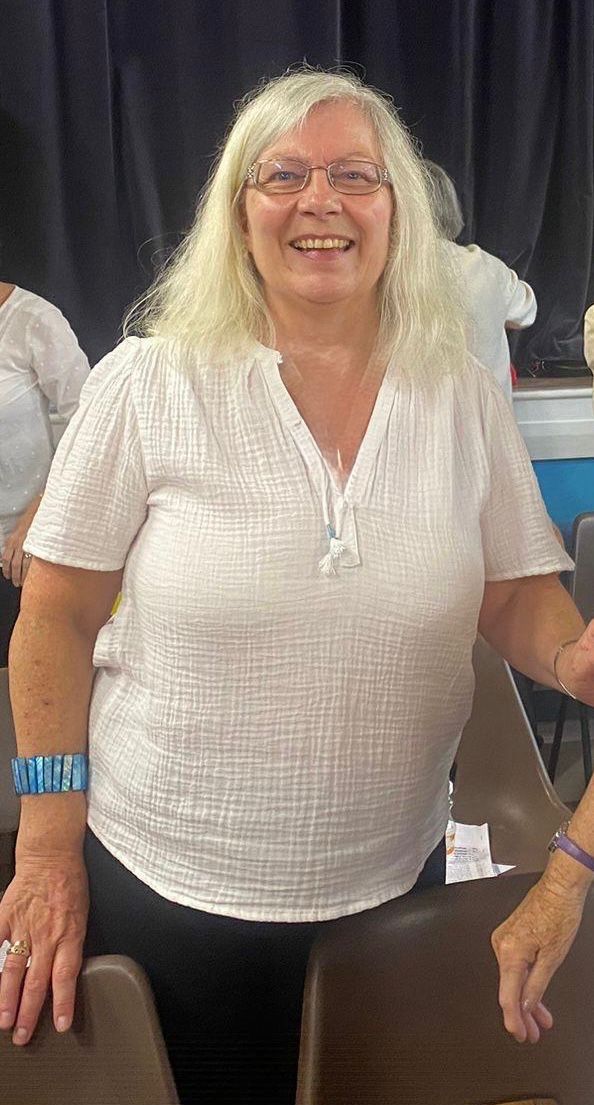 Teresa smiling in a white top at choir